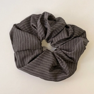 Detailed close-up of dark grey striped scrunchie with a premium cotton fabric texture