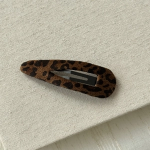 Detail of dark brown leopard print snap clip with soft flocked fabric texture