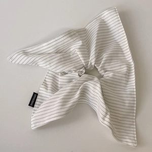 Detailed macro view of handmade striped fabric hair tie with black handmade label