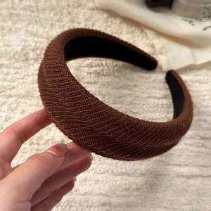 Detailed view of brown padded knit headband with sponge filling and wavy texture