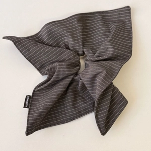 Detail of striped fabric scrunchie with a visible handmade woven label in close-up view