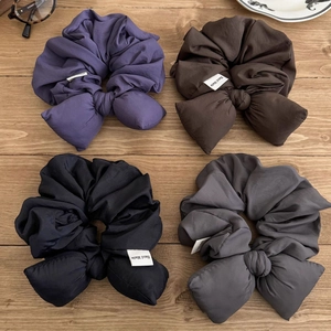 Chouchous élégants avec nœuds en violet, marron, noir et gris sur une surface en bois