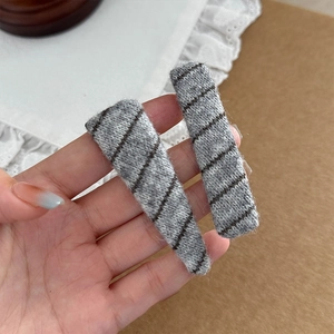 Knitted grey hair clips with black diagonal stripes including teardrop and rectangle shapes