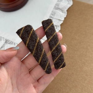Close-up of deep brown knitted twill hair clips set for winter accessories collection
