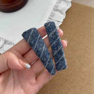 Detailed close-up of blue and white striped twill fabric hair clips for autumn