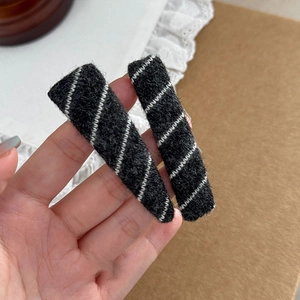 Close-up of autumn grey wool felt hair clips set with white diagonal twill stitching detail