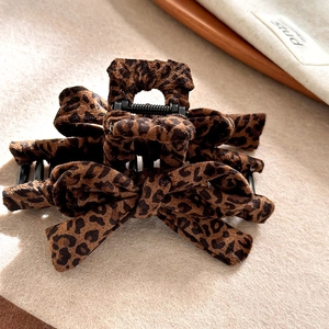 Close-up of leopard print bow hair claw clip showing soft fabric texture and firm grip