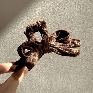 Large leopard print bow hair claw clip made of plush fabric for elegant women styling