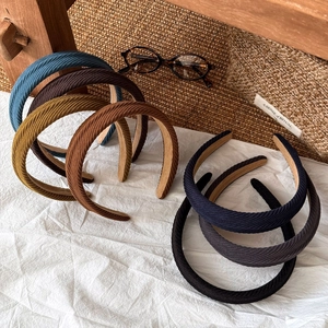 Vintage corduroy twill headbands in multiple earth tones on white fabric surface