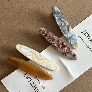 Set of four vintage acetate hair clips in amber, marble, and floral textures