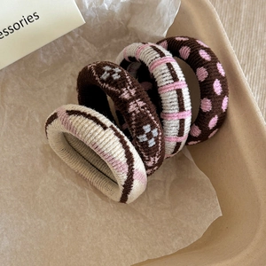 Detail of high-elasticity knit hair ties in brown and beige with classic patterns