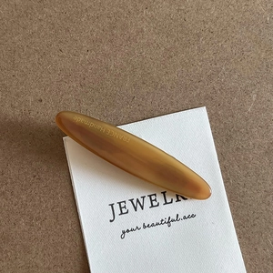 Detail of amber acetate hair clip showing the gold France Handmade logo engraving