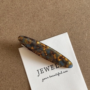 Detailed macro view of acetate hair clip showing marbled texture and France Handmade logo