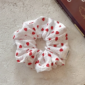 Sweet fabric scrunchie with strawberry print on textured white cloth for high ponytail hair
