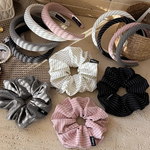Striped sponge headband and scrunchie set in assorted soft colors on stone background