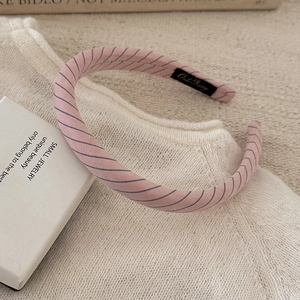 Detailed view of the pink striped padded headband with soft fabric texture and inner tag
