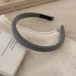 Close-up of grey twill fabric headband with soft matte texture on a lifestyle background
