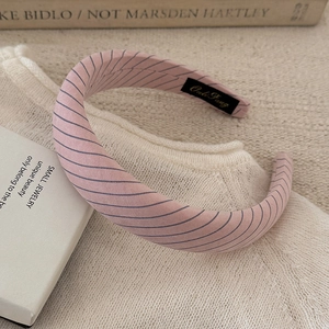 Close-up of pink striped headband with soft fabric texture and inner non-slip grip
