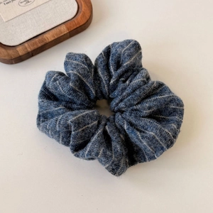 Detailed macro shot of blue striped knit scrunchie texture and soft pleated fabric