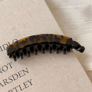 Dettaglio di un fermaglio a banana con stampa leopardata e presa a più denti
