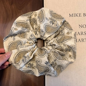 Close-up of vintage paisley print hair scrunchie with lace edge and cotton texture
