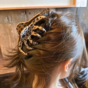 Detail view of large leopard print hair claw clip securing a thick updo hairstyle