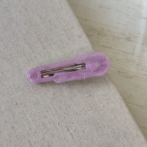 Dettaglio del fermaglio per capelli viola glitterato in acetato con scritta Girls e molla