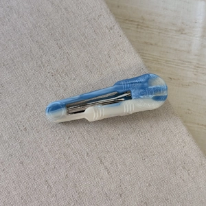 Dettaglio del fermaglio per capelli in acetato blu marmo con scritta Girls e base in metallo