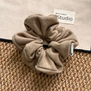 Brown knitted scrunchie with Happiness label and ribbed texture for ponytail