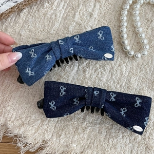 Dual denim bow hair clips in light and dark blue with elegant white ribbon patterns