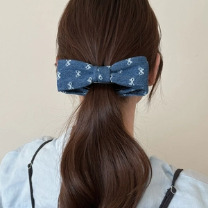Navy denim bow hair clip with white ribbon print shown on a ponytail for women
