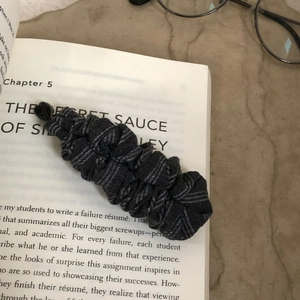 Detail showing high-quality pleated fabric banana hair clip with thin white stripes pattern