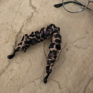 Close-up of leopard print fabric banana hair clip with elegant pleated texture on stone base