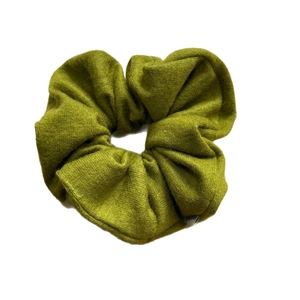 Grass green knitted scrunchie with Happiness label for elegant ponytail and bun styling