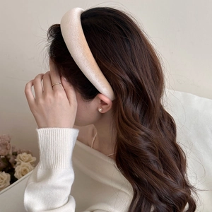 Close-up of a champagne gold padded velvet headband with high-top sponge design