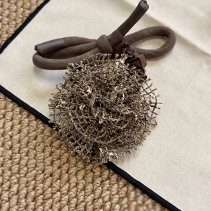 Détail d'un chouchou rose en tricot marron fait main avec une texture de maille complexe