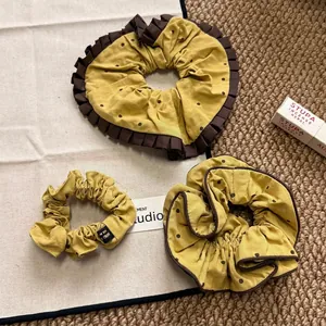 Three-piece mustard yellow polka dot scrunchie set with lace and ruffle edges