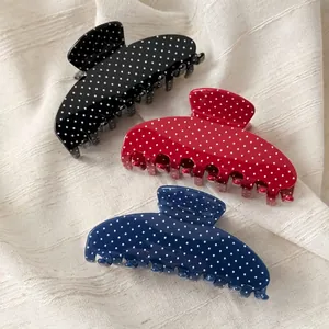 Three vintage acetate hair claws in black, red, and blue with white polka dot patterns