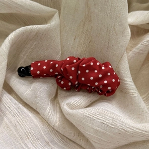 Vintage red polka dot pleated banana hair clip on a neutral linen background