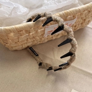 Detail of wool-wrapped headband with non-slip teeth and 'HAND MADE' leather label