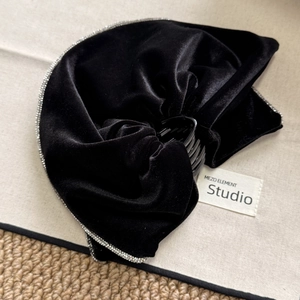 Detail of black velvet bow hair claw clip with sparkling rhinestone edge and resin grip