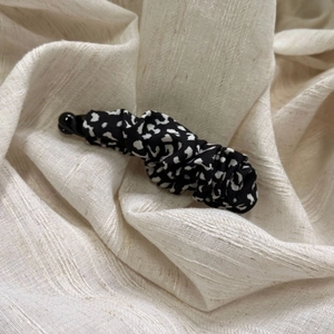 Detail of vintage leopard print banana clip on textured beige fabric background