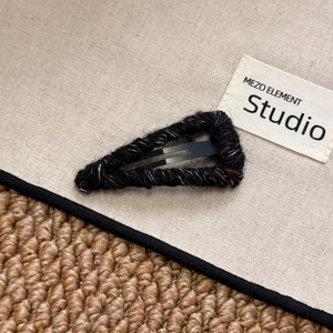 Detail of wool-wrapped triangle BB clip with textured knit finish in seasonal colors