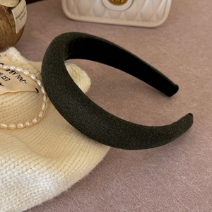 Close-up of moss green velvet padded headband with soft matte texture and thick sponge design