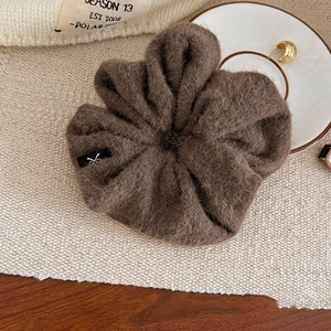 Détail d'un chouchou géant en peluche marron foncé avec une texture douce en fausse fourrure