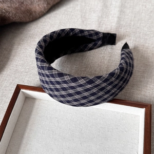 Close-up of classic navy and grey plaid fabric texture on a wide padded headband