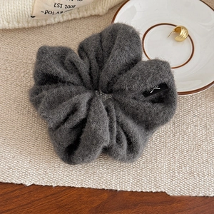 Gros plan d'un chouchou en laine grise avec étiquette tissée nœud et texture peluche