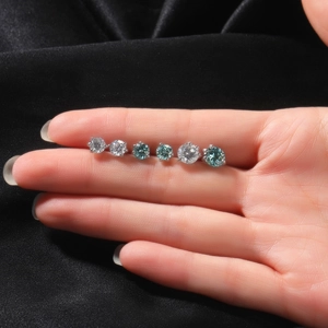 Macro-opname van S925 zilveren moissanite oorknopjes in wit en blauw getoond op een vinger