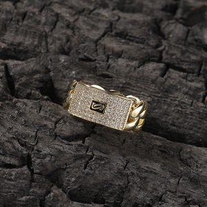 Close-up of golden Cuban link ring featuring a micro-paved zircon rectangular S signet