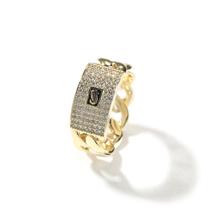 Macro shot of 14K gold Cuban chain ring with square paved zircon plate and S letter